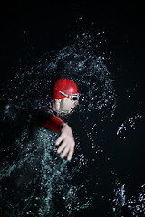 Image showing real triathlon athlete swimming in dark night