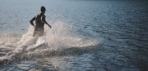 Image showing triathlon athlete starting swimming training on lake