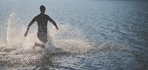 Image showing triathlon athlete starting swimming training on lake