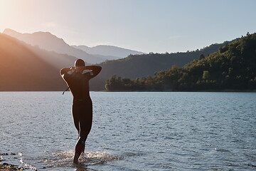 Image showing triathlon athlete starting swimming training on lake