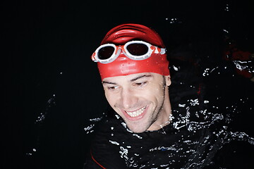 Image showing authentic triathlete swimmer having a break during hard training on night