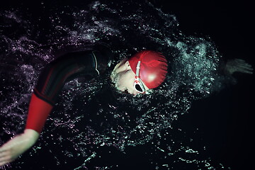 Image showing real triathlon athlete swimming in dark night