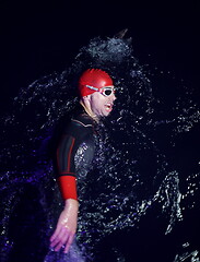 Image showing real triathlon athlete swimming in dark night