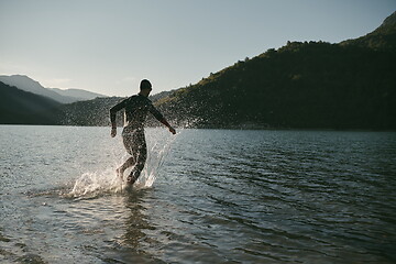 Image showing triathlon athlete starting swimming training on lake