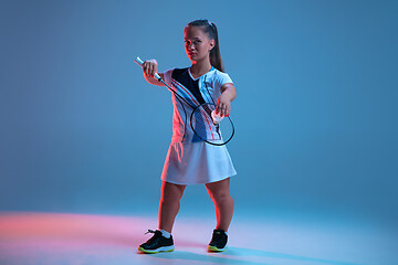 Image showing Beautiful dwarf woman practicing in badminton isolated on blue background in neon light