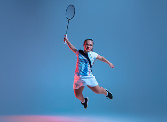 Image showing Beautiful dwarf woman practicing in badminton isolated on blue background in neon light