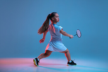 Image showing Beautiful dwarf woman practicing in badminton isolated on blue background in neon light