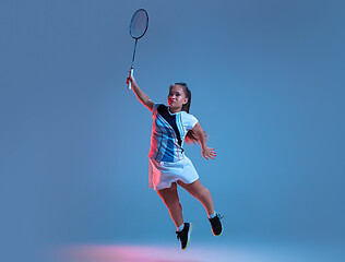 Image showing Beautiful dwarf woman practicing in badminton isolated on blue background in neon light