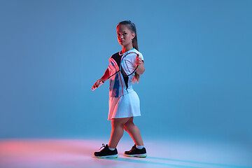 Image showing Beautiful dwarf woman practicing in badminton isolated on blue background in neon light