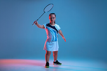 Image showing Beautiful dwarf woman practicing in badminton isolated on blue background in neon light