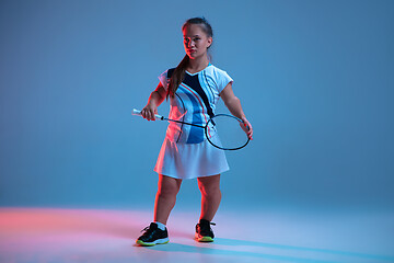 Image showing Beautiful dwarf woman practicing in badminton isolated on blue background in neon light
