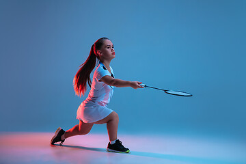 Image showing Beautiful dwarf woman practicing in badminton isolated on blue background in neon light