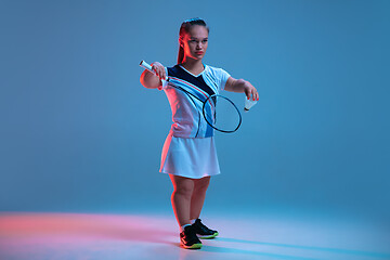 Image showing Beautiful dwarf woman practicing in badminton isolated on blue background in neon light