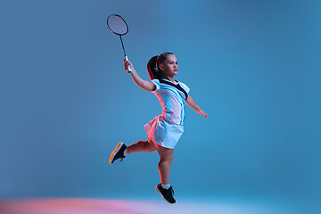 Image showing Beautiful dwarf woman practicing in badminton isolated on blue background in neon light