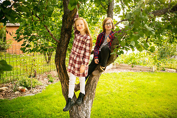 Image showing Happy brother and sister playing in a garden outdoors together