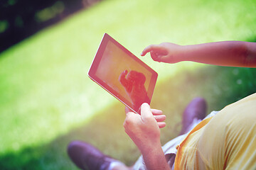 Image showing grandfather and child in park using tablet