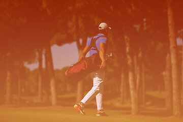 Image showing golf player walking and carrying bag