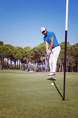 Image showing golf player hitting shot at sunny day