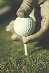 Image showing golf player placing ball on tee