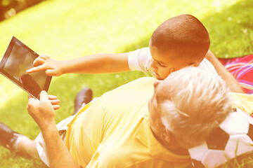 Image showing grandfather and child in park using tablet