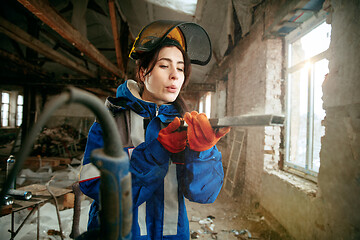 Image showing Woman wearing helmet using male work tools