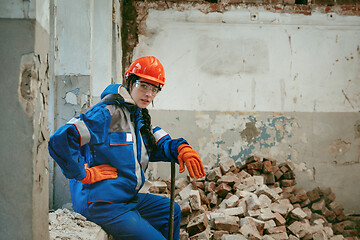 Image showing Woman wearing helmet using male work tools