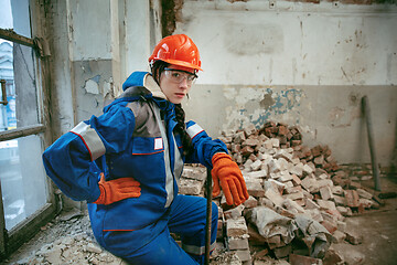 Image showing Woman wearing helmet using male work tools