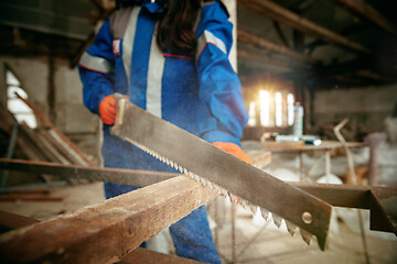 Image showing Woman wearing helmet using male work tools