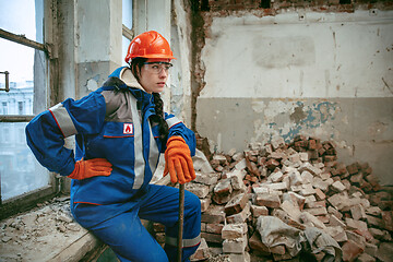 Image showing Woman wearing helmet using male work tools