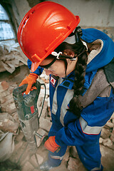 Image showing Woman wearing helmet using male work tools