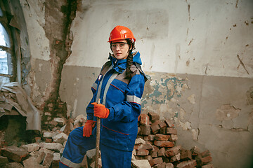 Image showing Woman wearing helmet using male work tools