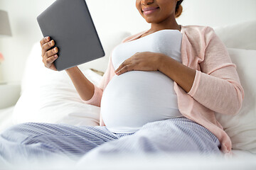 Image showing close up of pregnant woman with tablet pc at home