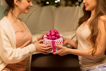 Image showing happy female friends with christmas gift at home