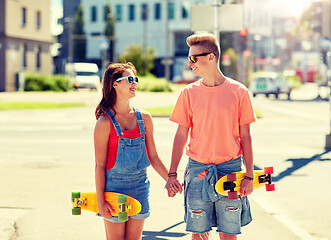 Image showing teenage couple with skateboards on city street