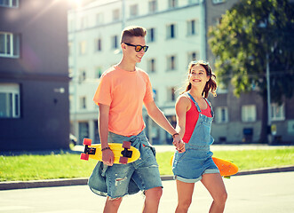 Image showing teenage couple with skateboards on city street