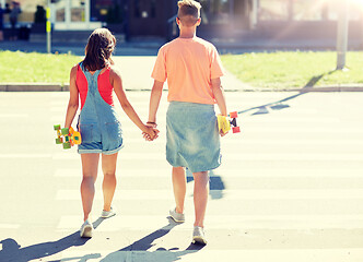 Image showing teenage couple with skateboards on city crosswalk