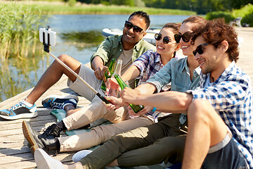 Image showing friends with drinks taking selfie on lake pier