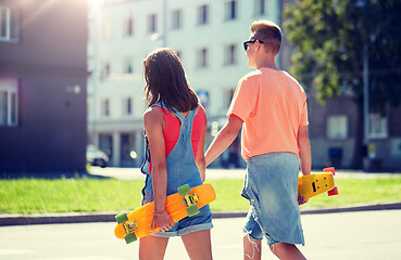 Image showing teenage couple with skateboards on city crosswalk