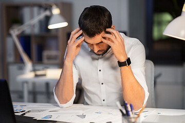 Image showing businessman with papers working at night office