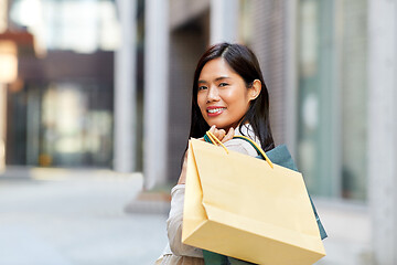 Image showing asian woman with shopping bags in city