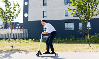 Image showing young businessman riding electric scooter outdoors