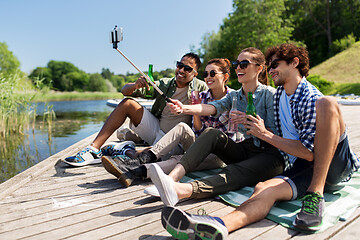 Image showing friends with drinks taking selfie on lake pier