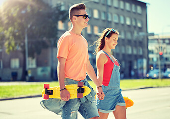 Image showing teenage couple with skateboards on city street