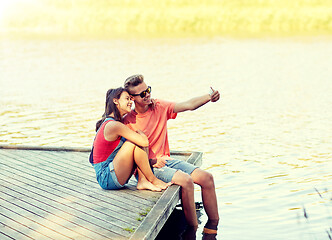 Image showing happy teenage couple taking selfie on smartphone