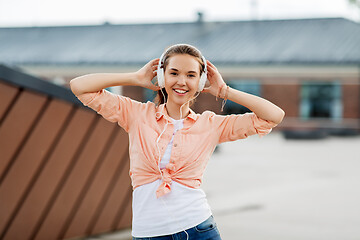 Image showing happy teenage girl with headphones in city