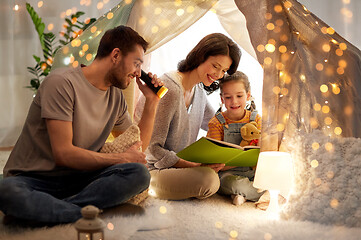 Image showing happy family reading book in kids tent at home