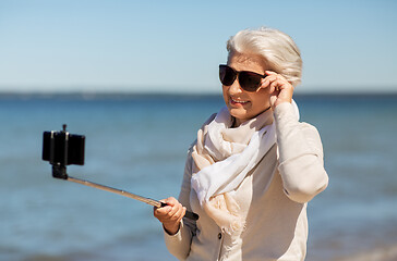 Image showing senior woman taking selfie on beach