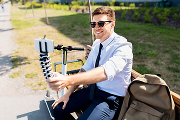 Image showing businessman taking selfie by smartphone in city