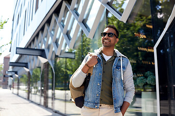 Image showing indian man with backpack walking along city street