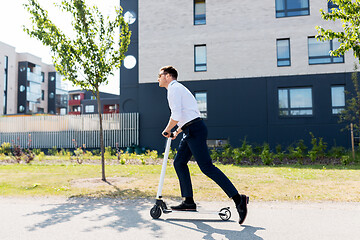 Image showing young businessman riding electric scooter outdoors